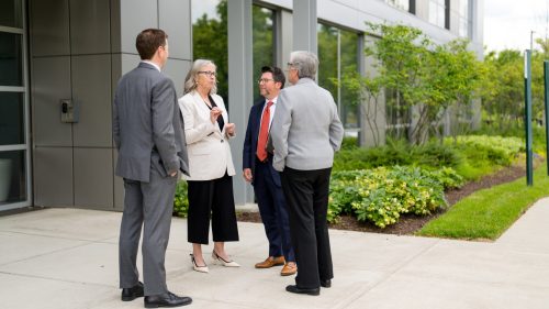 Professional discussion among attorneys outdoors, dressed in business attire, conveys collaboration and focus.