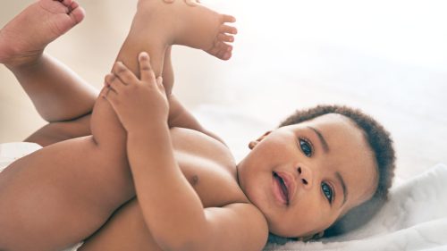 Smiling baby lying on back, conveying innocence and joy.
