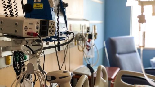 Hospital room with medical equipment and patient bed, conveying a clinical atmosphere.