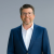 Smiling professional man in suit and glasses, conveying trust and expertise.