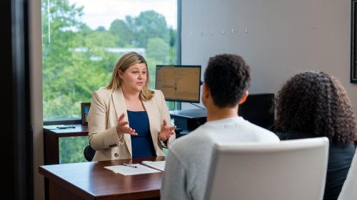 Lawyer discussing case details with clients in a professional office setting.