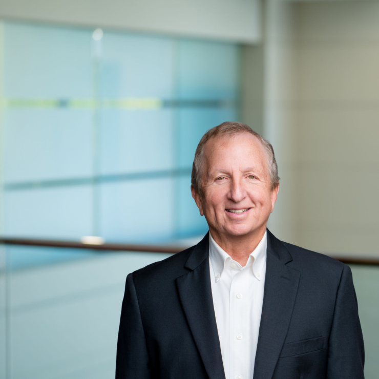 Smiling professional man in suit against modern office background.