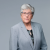 Professional woman in gray suit, conveying confidence and expertise.