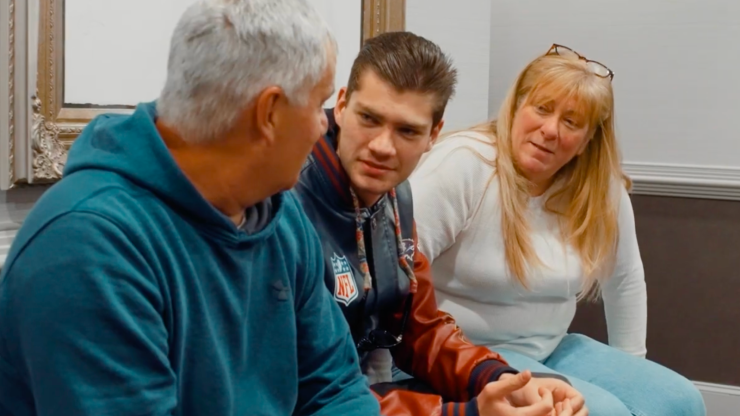Three people sitting together, engaged in a supportive and serious conversation.