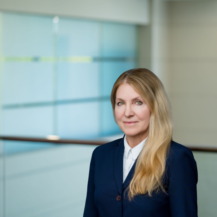 Professional woman in suit in modern, formal legal office setting.