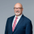 Professional man in suit smiling confidently, conveying experience and trustworthiness.