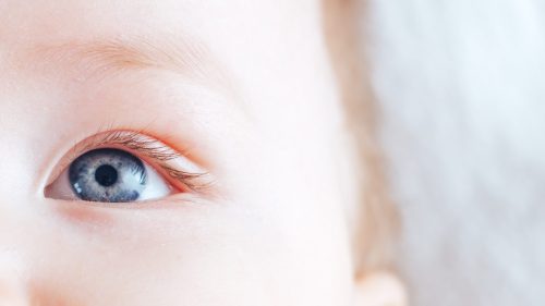 Close-up of a baby's eye, conveying innocence and vulnerability.