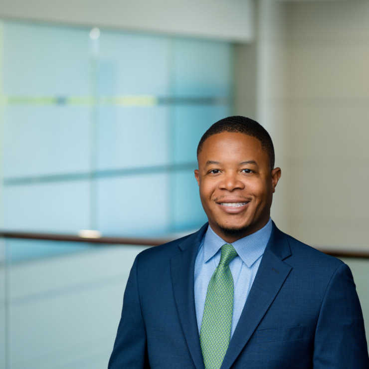 Professional lawyer in a suit, confidently smiling in a modern office setting.