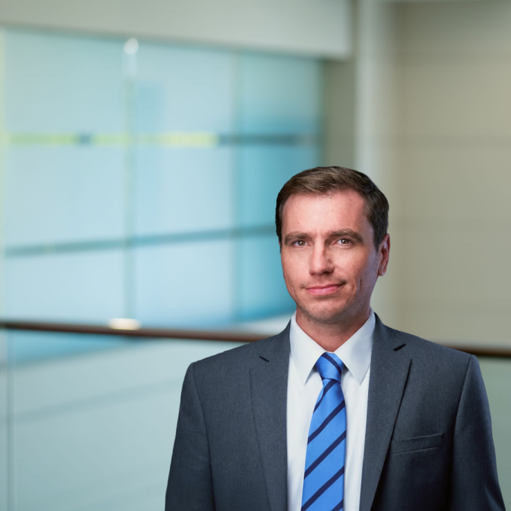 Professional man in a suit with a confident expression, modern office background.