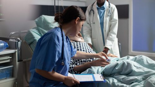 Doctors attentively caring for a patient in a hospital bed.
