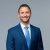 Smiling lawyer in a blue suit and tie, professional and approachable demeanor.