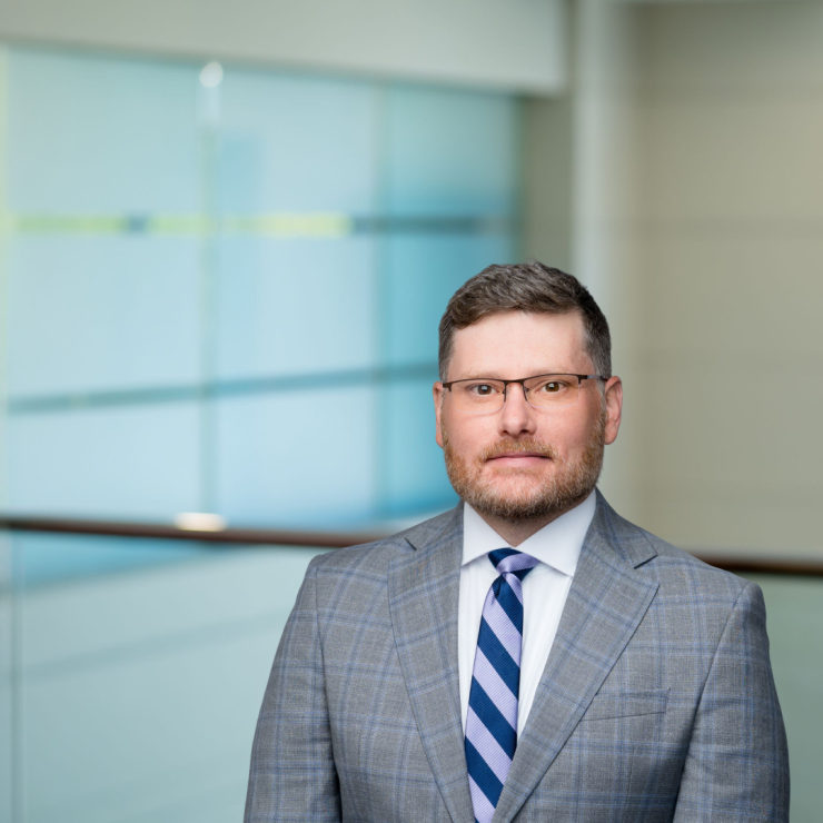Professional man in a suit standing confidently in a modern office environment.