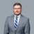 Professional headshot of a lawyer in a suit with a neutral background.