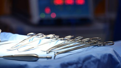 Surgical instruments neatly arranged on a blue drape, highlighting clinical precision.