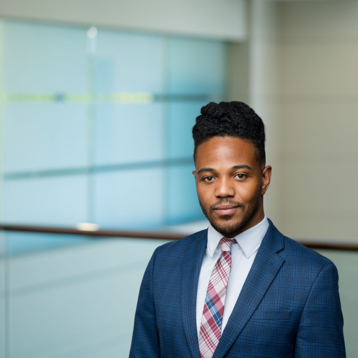 Professional lawyer in a suit, standing confidently in a modern office.
